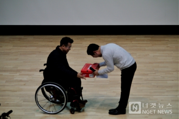 김승원 후보가 지난 1월 12일 자신의 출판기념회에서 열심이 뛰어다라는  장애인 대표에게 신발을 선물받고 있다(사진=김규용 기자)