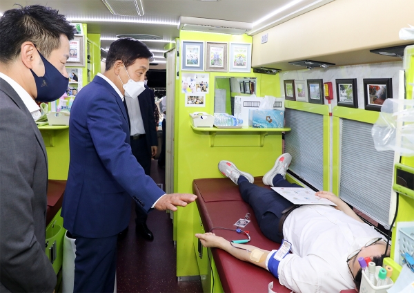 김정태 하나금융 회장(가운데)이 17일 명동사옥 야외주차장에 마련된 헌혈버스를 찾아 헌혈 캠페인에 참여한 직원을 격려하고 있다. 사진=하나금융지주