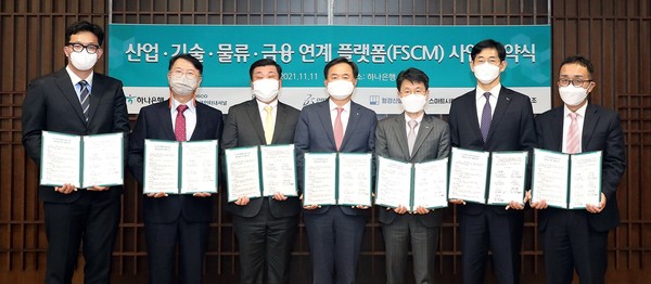 하나은행은 11일 포스코 인터내셔널(구매&물류), 포스코 A&C(산업), 다쏘시스템(기술), 형경산업(제작)과 함께 ‘산업․기술․물류․금융을 융합해 B2B 플랫폼’ 사업 추진을 위한 업무협약을 체결했다. 왼쪽부터 이재경 오조 대표, 정훈 포스코에이앤씨 건축사무소장, 김병휘 포스코인터내셔널 본부장, 박지환 하나은행 부행장, 조영빈 다쏘시스템코리아 대표, 박형순 형경산업 대표, 진춘식 스마트시티도시개발 대표. 사진=하나은행