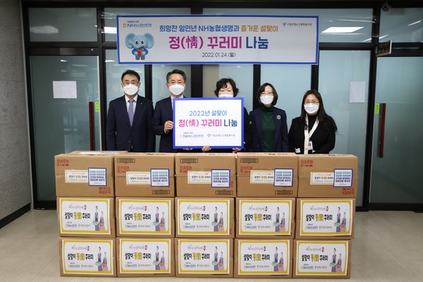 NH농협생명 김인태 대표이사(왼쪽 두 번째), 은평노인종합복지관 김승자 관장(왼쪽 세 번째) 및 관계자가 정(情)꾸러미 나눔 기념 촬영을 하고 있다. 사진=NH농협생명