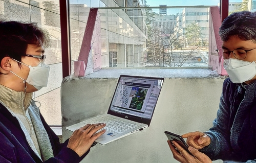 LG유플러스 직원들이 RIS가 장착된 유리창 앞에서 통신품질을 점검하고 있는 모습. 사진=LG유플러스