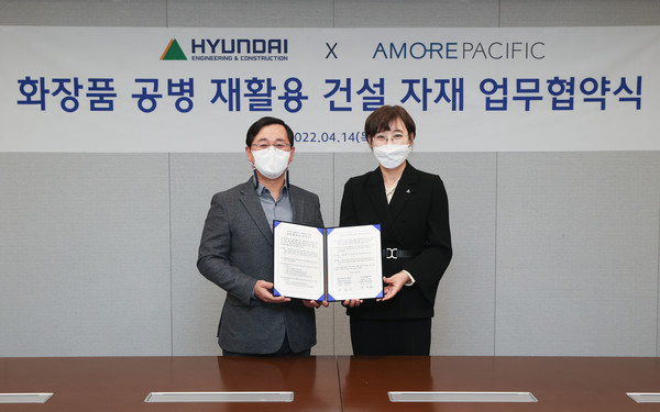 14일 이인기 현대건설 건축주택설계실장 상무(왼쪽)와 오정화 아모레퍼시픽 지속가능경영 디비전 상무(오른쪽)가 '플라스틱 화장품 공병 재활용 건설 자재 업무 협약식'을 마치고 기념촬영을 하고있다. 사진=아모레퍼시픽