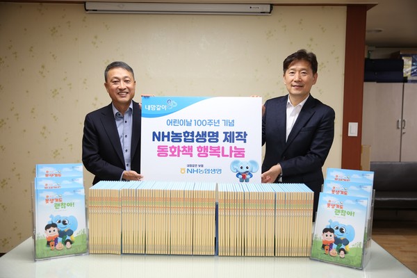 지난 3일 서울 은평구 행복창조 노인복지센터에서 류영수 NH농협생명 경영기획부문 부사장(왼쪽)과 김현훈 사단법인 행복창조 이사장이 동화책 나눔을 기념하며 사진을 촬영하고 있다. 사진=NH농협생명