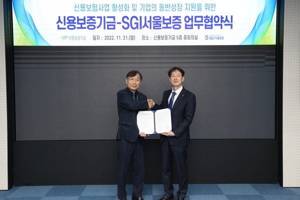 21일 대구광역시 동구 신용보증기금 본사에서 황의탁 SGI서울보증 전무이사(오른쪽)와 조충행 신용보증기금 상임이사(왼쪽)가 ‘매출채권보험 사업 활성화 및 기업의 동반성장 지원을 위한 업무협약’ 체결 후 기념촬영을 하고 있다. 사진=SGI서울보증