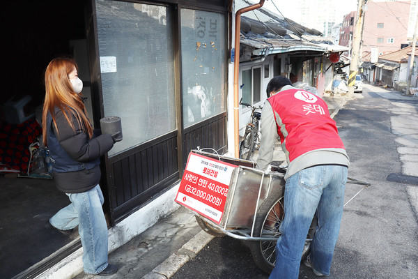 롯데건설 직원과 서울연탄은행 소속 사회복지사가 서울 104마을에서 ‘사랑의 연탄 나눔’에 참여하고 있다. 사진=롯데건설