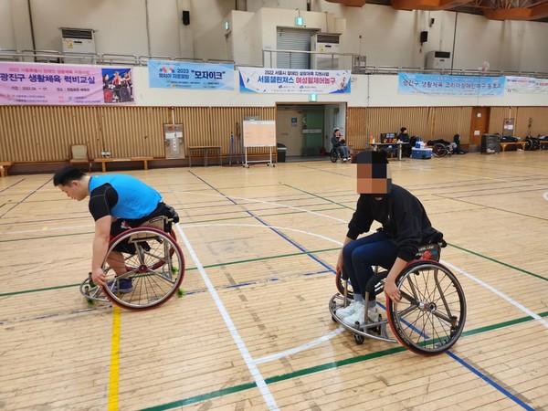 양동길 주장(왼쪽)과 함께 휠체어 농구 체험 중인 기자. 사진=코웨이