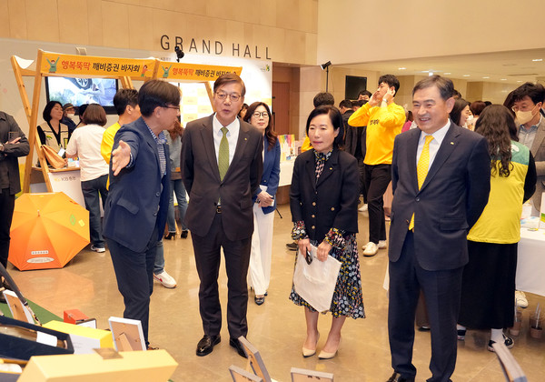 노종갑 커뮤니케이션 본부장(왼쪽에서 첫 번째)이 KB증권 박정림 대표(왼쪽에서 세 번째)와 김성현 대표(왼쪽에서 네 번째), 초록우산 어린이재단 황영기 회장(왼쪽에서 두 번째)에게 바자회 물품을 안내하고 있다. 사진= KB증권