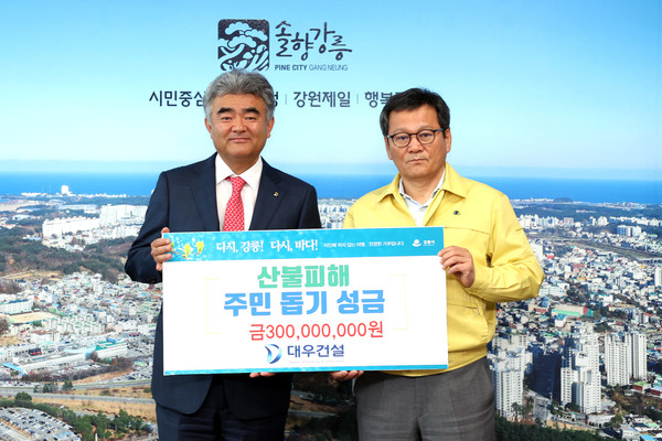 정원주 중흥그룹 부회장(왼쪽)과 김홍규 강릉시장(오른쪽)이 성금 전달 후 사진을 촬영 중이다. 사진=대우건설