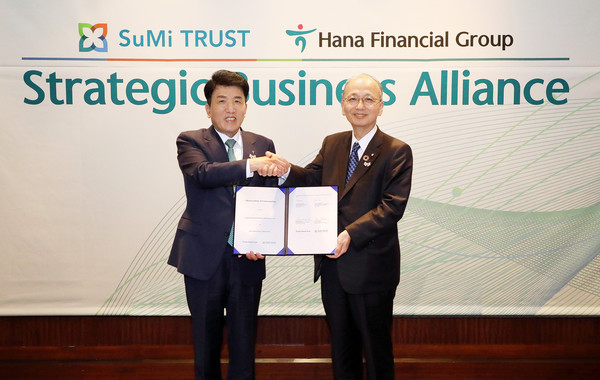 협약식에 참석한 함영주 하나금융그룹 회장(왼쪽)이 다카쿠라 토오루 스미트러스트 사장과 협약서를 들고 기념 촬영을 하고 있다. 사진=하나금융지주