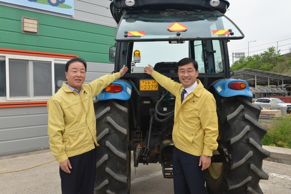 3일 전남 나주시에서 최문섭 NH농협손해보험 대표이사(왼쪽)와 윤종철 농촌진흥청 차장(오른쪽)이 농기계 사고예방시스템 설치 후 기념촬영을 하고 있다. 사진=NH농협손해보험