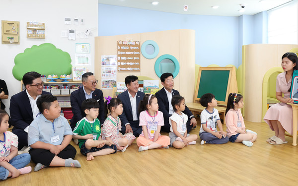 어린이집을 방문한 이은형 하나금융그룹 부회장(사진 뒷줄 왼쪽에서 첫 번째), 이동우 롯데지주 부회장(왼쪽에서 두 번째), 정기명 여수시장(왼쪽에서 세 번째), 우태희 대한상공회의소 상근부회장(왼쪽에서 네 번째)이 교육 프로그램에 직접 참여해 어린이들과 함께 설명을 듣고 있다. 사진=하나금융지주