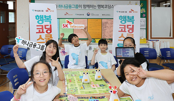 강원도 인제군 용대초등학교에서 ‘행복코딩스쿨’ 프로그램에 참여한 초등학생이 코딩 로봇과 함께 포즈를 취하고 있다. 사진=하나금융지주