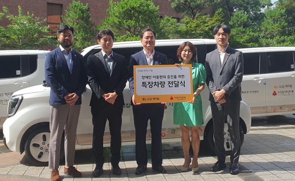 황수남 KB캐피탈 대표이사(오른쪽 세번째)와 김경희 사랑의 열매  본부장(우른쪽 두번째)이 차량을 전달받은 사회복지 단체 관계자들과 기념촬영을 하고 있다. 사진=KB캐피탈