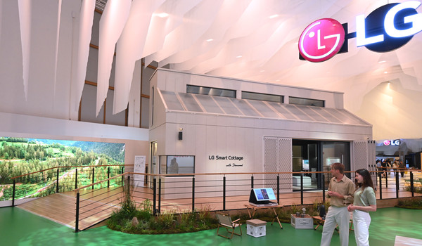 독일 메세 베를린(Messe Berlin) 내 LG전자 전시관 'LG 지속가능한 마을(LG Sustainable Village)' 입구에서 모델들이 에너지 및 냉난방공조 시스템, 차별화된 프리미엄 가전을 갖춘 소형 모듈러 주택 ‘LG 스마트코티지’를 소개하는 모습. 사진=LG전자