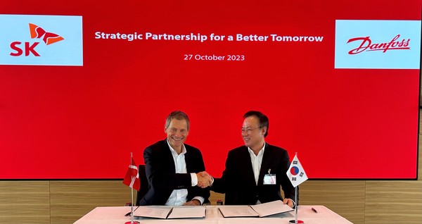 장동현 SK(주) 부회장(오른쪽), 킴 파우징(Kim Fausing) 댄포스 CEO가 양해각서에 서명한 뒤 악수하고 있다. 사진=SK(주)