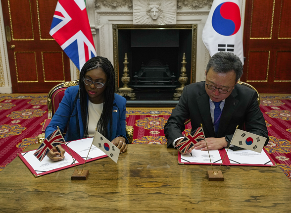 업무협약식에서 영국 기업통상부 케미 베데노크 내각장관(왼쪽)과 신한은행 정상혁 은행장이 협약서에 서명하는 모습. 사진=신한은행