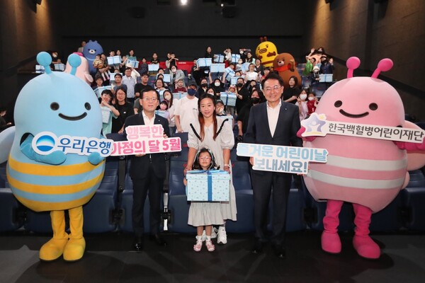 조병규 은행장(왼쪽 두번째)과 장광익 브랜드홍보그룹 부행장(오른쪽 두번째)이 소아암 홍보대사 어린이 가족과 함께 기념촬영을 하고 있다. 사진=우리은행