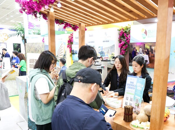 지난 9일부터 12일까지 서울 강남구 코엑스에서 진행된 제39회 서울국제관광전 내 괌정부관광청 홍보 부스에서 참여자들이 이벤트를 확인하고 있다. 사진 = 괌정부관광청