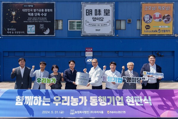 농협은행 이석용 은행장(왼쪽 네 번째)과 우리식품 이상준 대표이사(왼쪽 다섯 번째)를 비롯한 양사 임직원이 현판식을 갖고 기념촬영을 하고 있다. 사진=NH농협은행