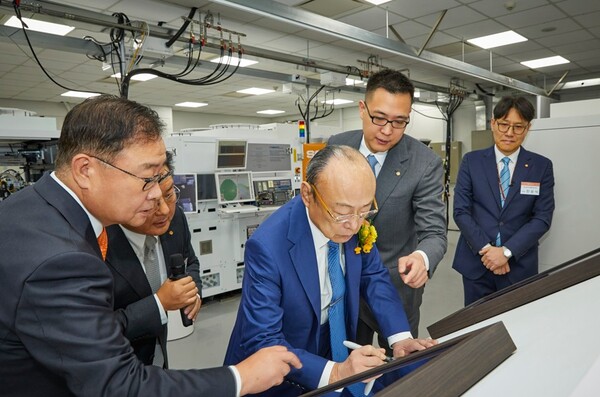 김승연 한화그룹 회장(왼쪽에서 세번째)이 삼남 김동선 한화비전 미래비전총괄 부사장(왼쪽에서 네번째)과 한화 판교 R&D센터를 방문해 한화정밀기계가 준비한 방명록에 서명하고 있다. 사진=한화그룹