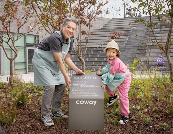 코웨이 서장원 대표(왼쪽)와 임직원 자녀가 '코웨이 생태숲 1호' 현판 앞에서 기념 촬영을 하고 있다. 사진=코웨이