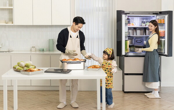 삼성전자 모델들이 김치 냄새 퍼짐을 줄여주는 '냄새 케어 김치통'에 김장 김치를 담아 '비스포크 AI 김치플러스'에 보관하고 있다. 사진=삼성전자