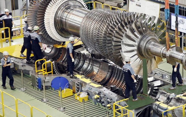  2019년 9월 두산에너빌리티 직원들이 가스터빈 초도호기 최종조립을 위해 로터 블레이드를 케이싱에 설치하고 있다. 사진=두산에너빌리티