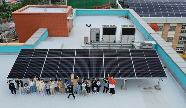 거제 상동초등학교의 학생들이 맑은학교 만들기를 통해 건물 옥상에 설치된 태양광 설비를 살펴보고 있다. 사진=한화그룹