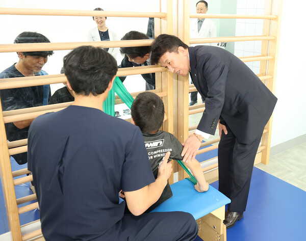 함영주 회장(맨 오른쪽)이 중추신경계 발달치료를 받고 있는 장애 아동에게 따뜻한 격려의 말을 전하고 있다. 사진=하나금융지주