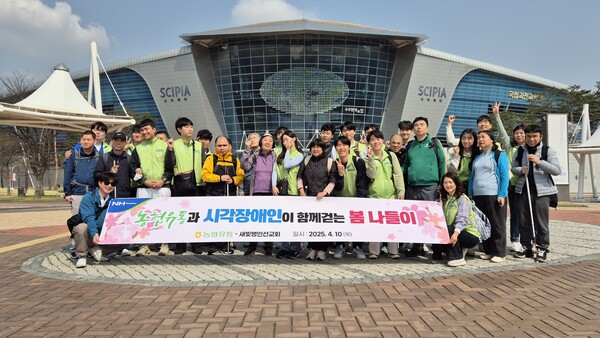 농협유통 임직원과 새빛맹인선교회 시각장애인들이 기념 촬영을 하고 있다. 사진=농협유통