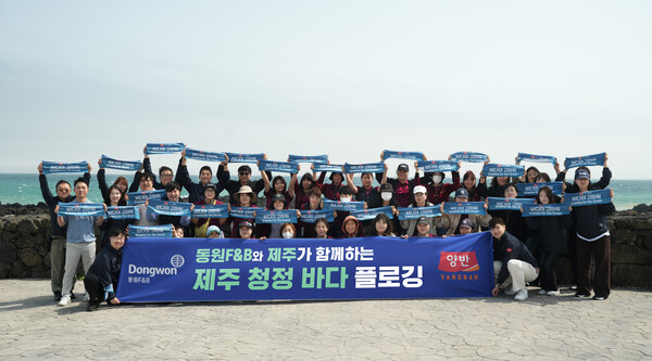 지난 18일 서귀포시 표선면 일대에서 진행된 '제주 청정 바다 플로깅' 행사에서 동원F&B 직원들이 기념 사진 촬영을 하고 있다. 사진=동원F&B
