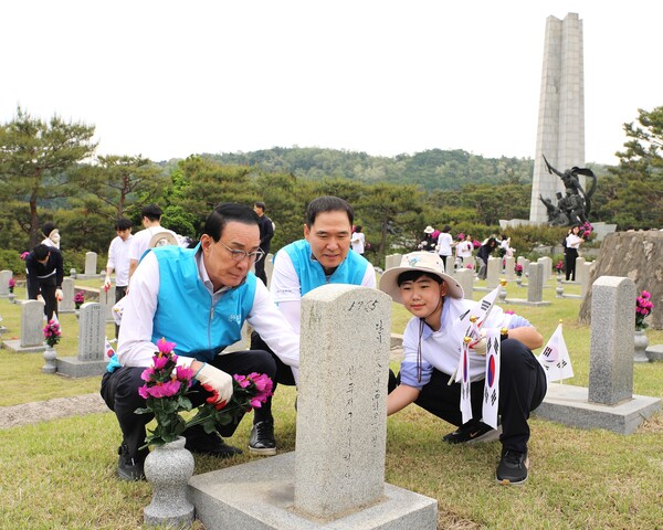 노동진 수협중앙회장(왼쪽 첫 번째)과 신학기 Sh수협은행장, 임직원 자녀가 헌화와 태극기 꽂기 등 묘역 돌봄활동을 펼치는 모습, 사진=Sh수협은행