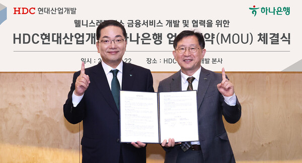 이호성 하나은행장(사진 왼쪽)이 정경구 HDC현대산업개발 대표이사(사진 오른쪽)와 함께 협약서를 들고 기념촬영을 하고 있다, 사진=하나은행